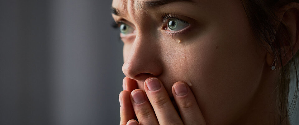 Women looking deep in thought, worried with tears and hands covering mouth